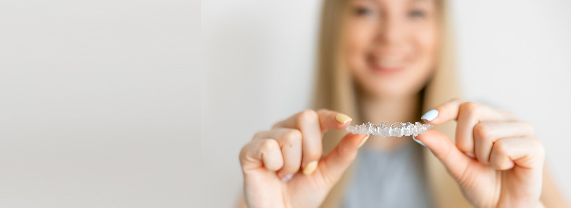 A person holding up a small object with their hand against a white background.