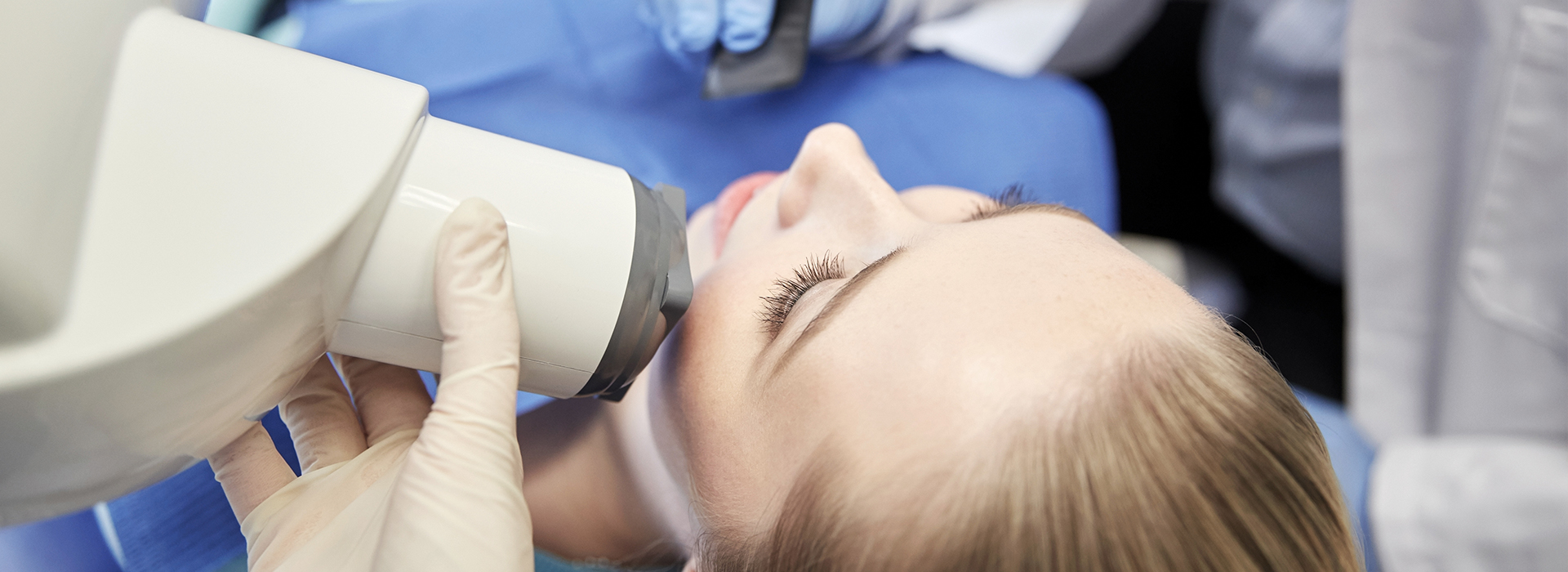 A person receiving a facial peel treatment under the supervision of a medical professional.