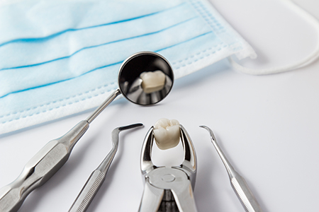 Dental tools on a white surface with blue gauze.